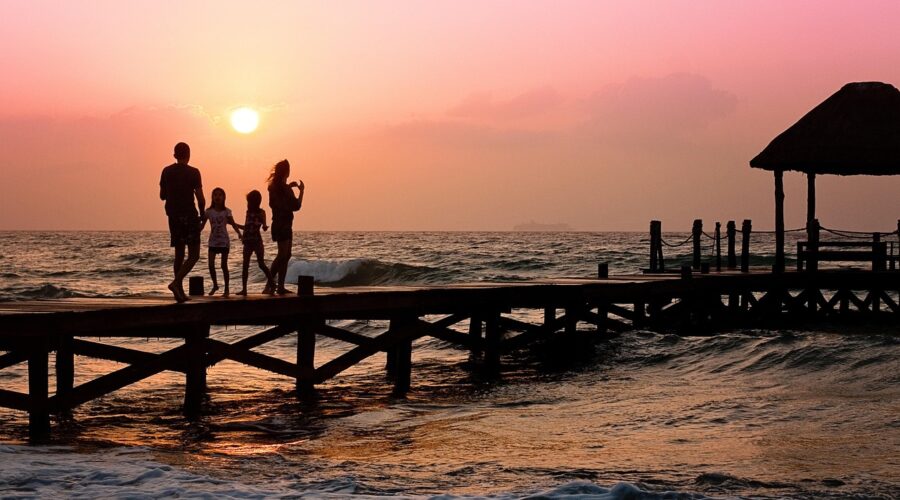Family walking together on a pier at sunset