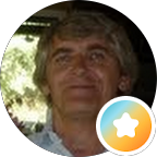 Profile photo of a man with gray hair outdoors, with a small orange badge showing a white star in the bottom-right corner.